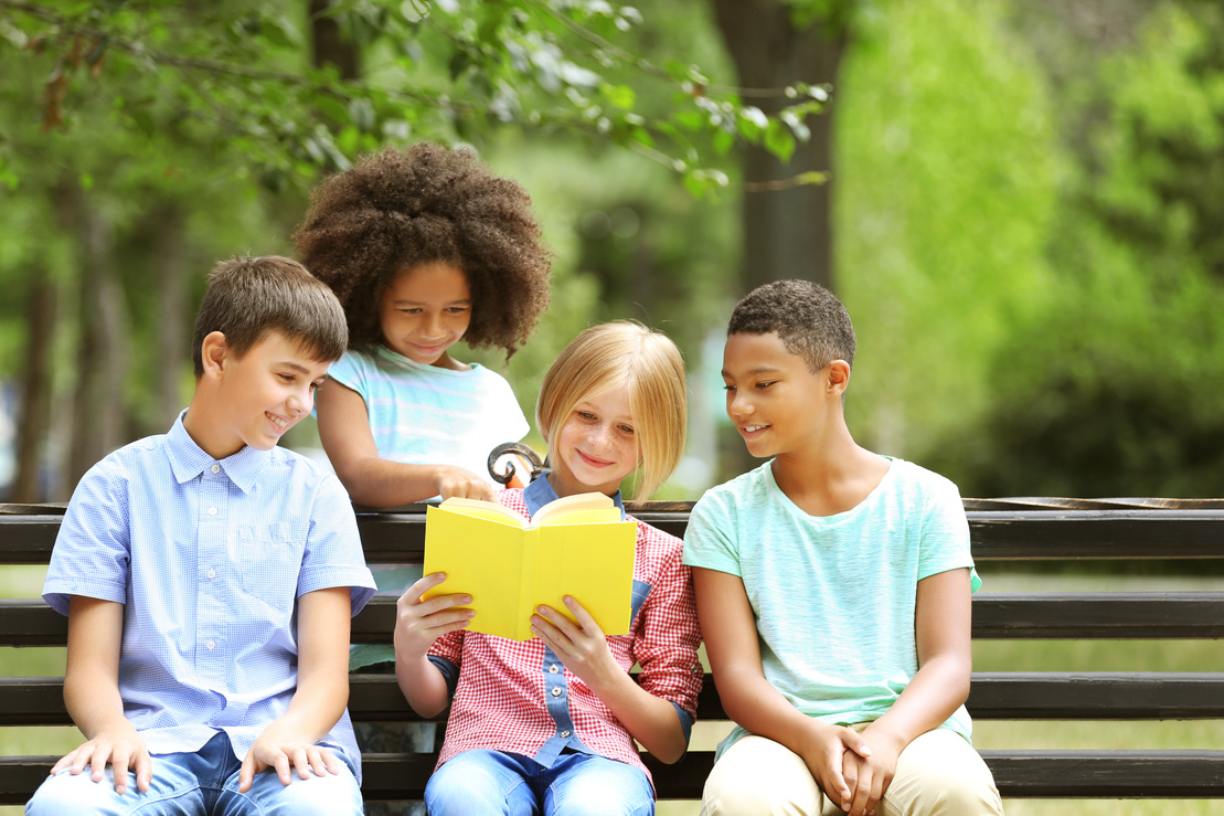 Cute Kids Reading Book on Bench